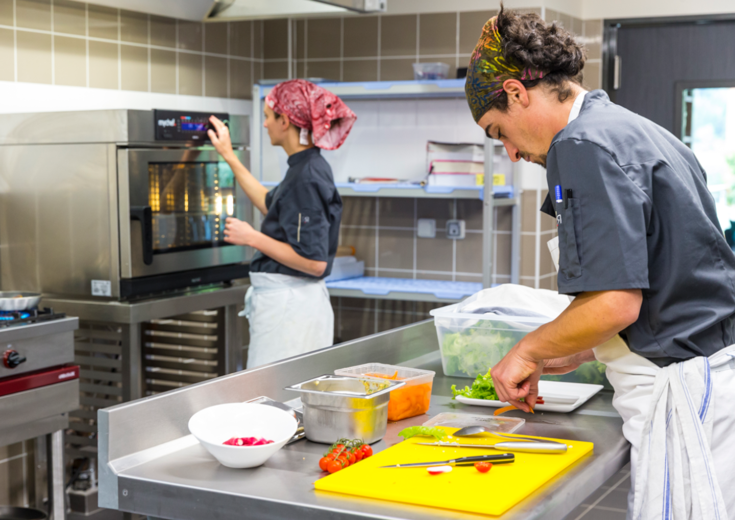 Deux commis travaillent dans les cuisines d'un restaurant - © Juan Robert Deux commis travaillent dans les cuisines d'un restaurant