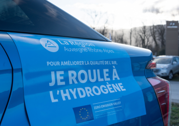 Photo d'une voiture sur laquelle il est écrit "Pour améliorer la qualité de l'air, je roule à l'hydrogène"