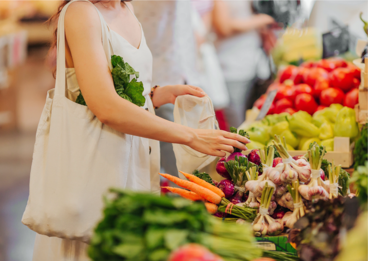 Photo d'une femme touchant les fruits et légumes sur l'étal dans un marché